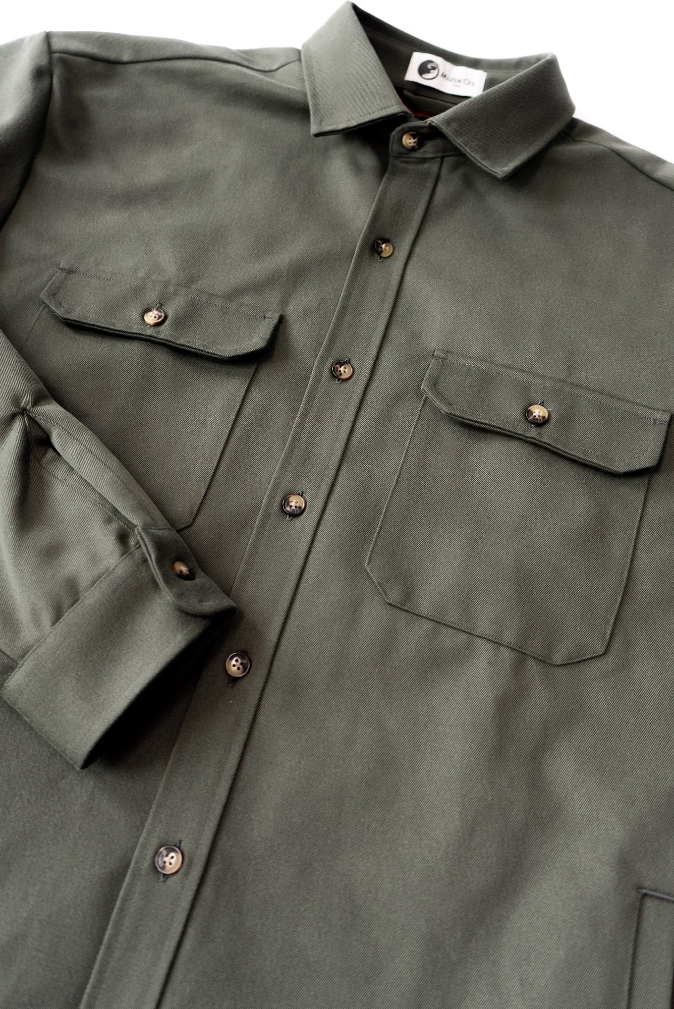 Green shirt with button details on a plain background