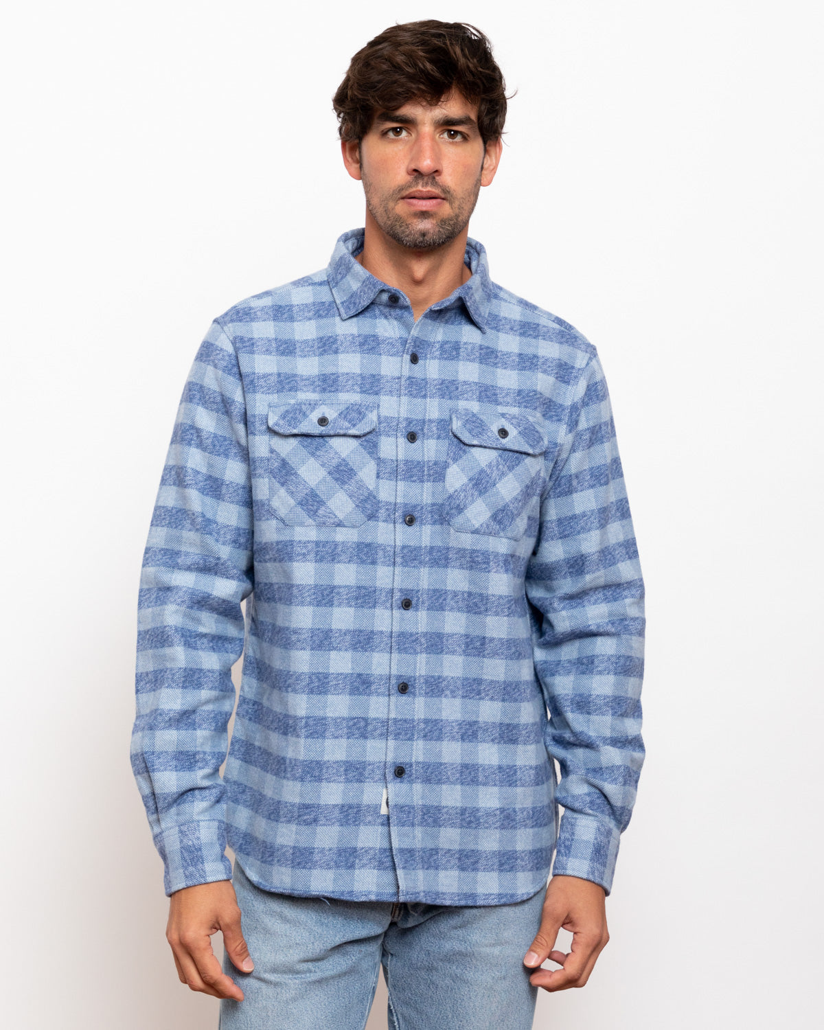 Man wearing a blue plaid shirt against a white background