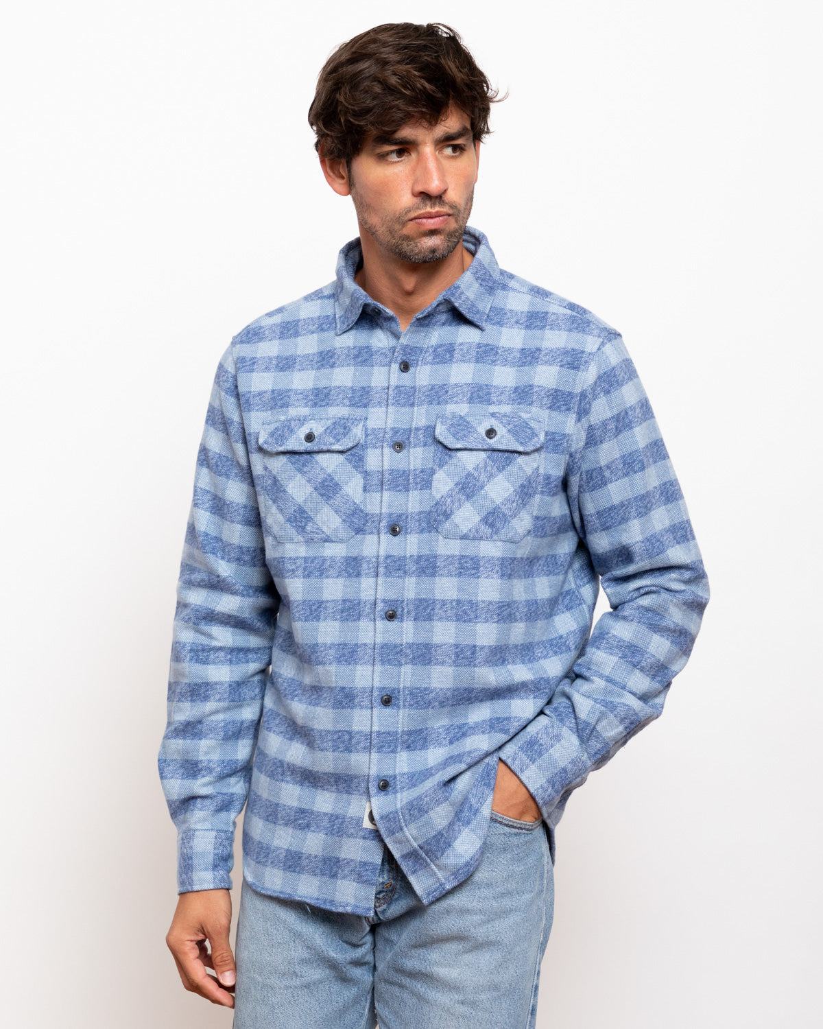 Man wearing a blue plaid shirt against a white background