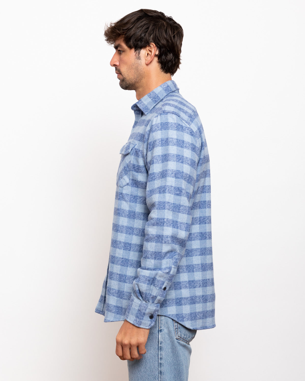 Man wearing a blue checkered shirt against a white background